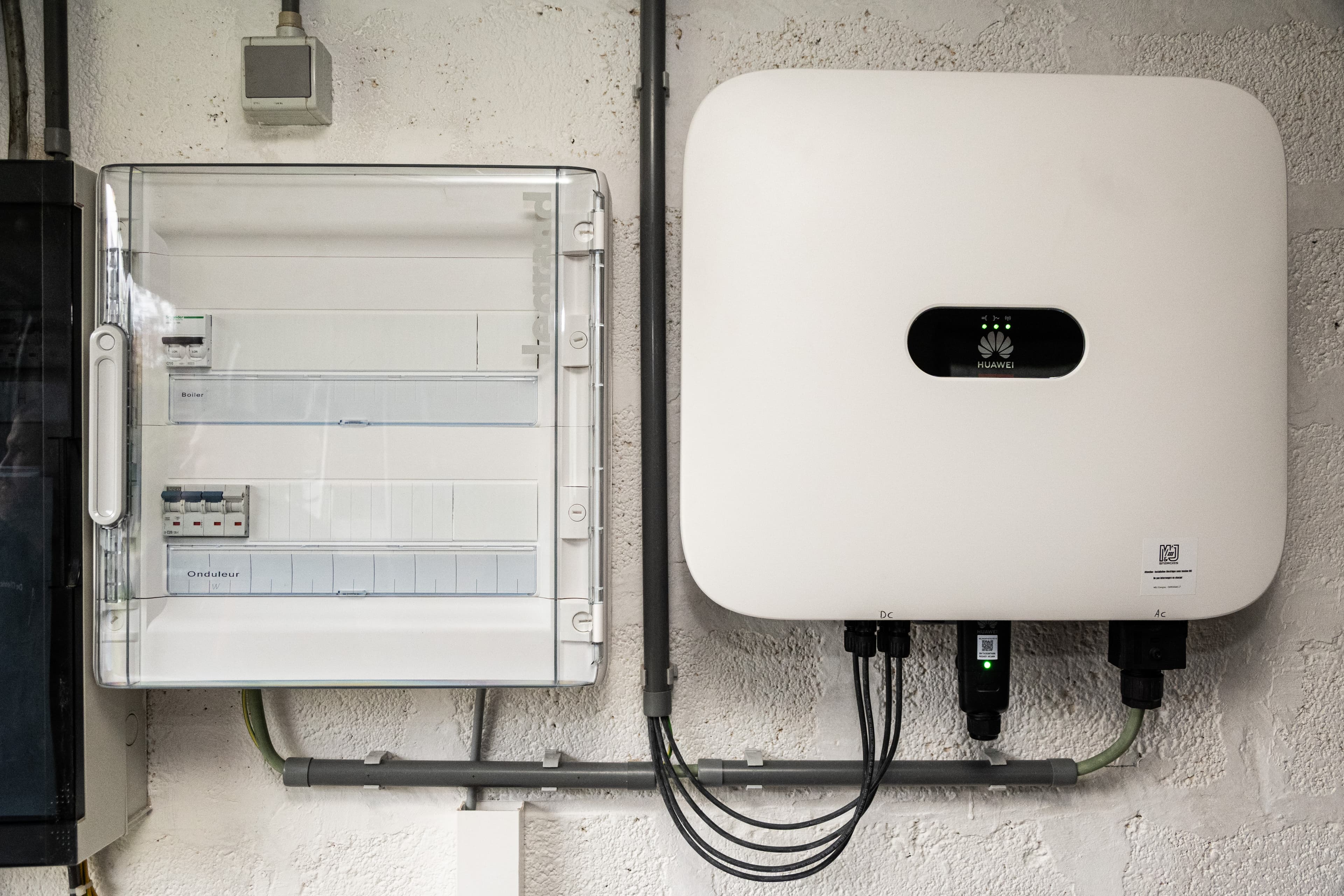 Onduleur et tableau electrique installes sur un mur.